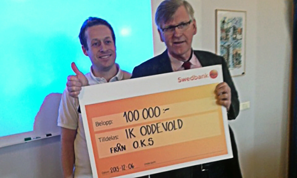 Tommy Carlsson från supporterklubben överlämnar checken på 100 000 kr till Oddevolds Ordförande Stefan Mattsson.